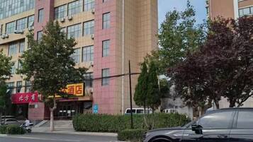 A multi-story building with a red sign indicating a hotel.