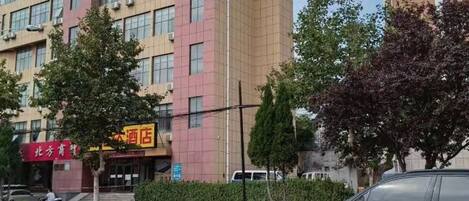 A multi-story building with a red sign indicating a hotel.