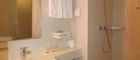 A bathroom with a sink, mirror, towel rack, and shower.