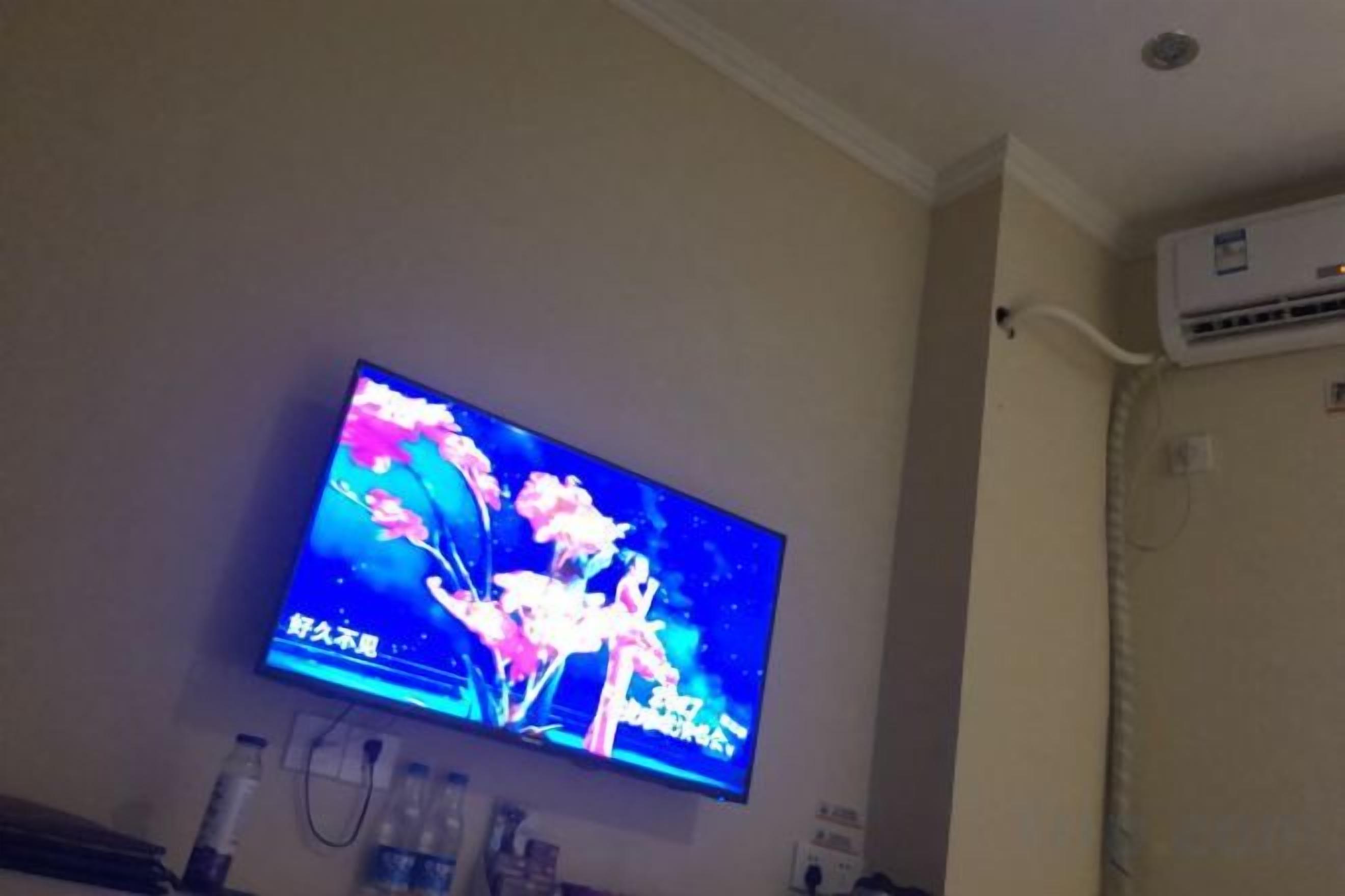 Un televisor montado en la pared mostrando una escena floral.