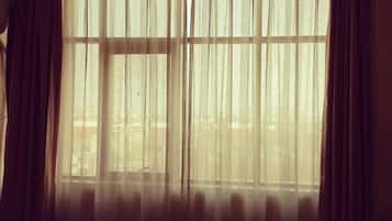 A room with a large window covered by sheer curtains, allowing natural light to enter.