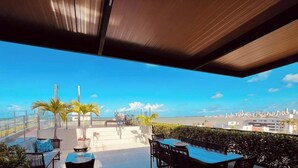 An outdoor terrace with a city view, seating, and a railing. - LM OZEAN (Joao Pessoa)