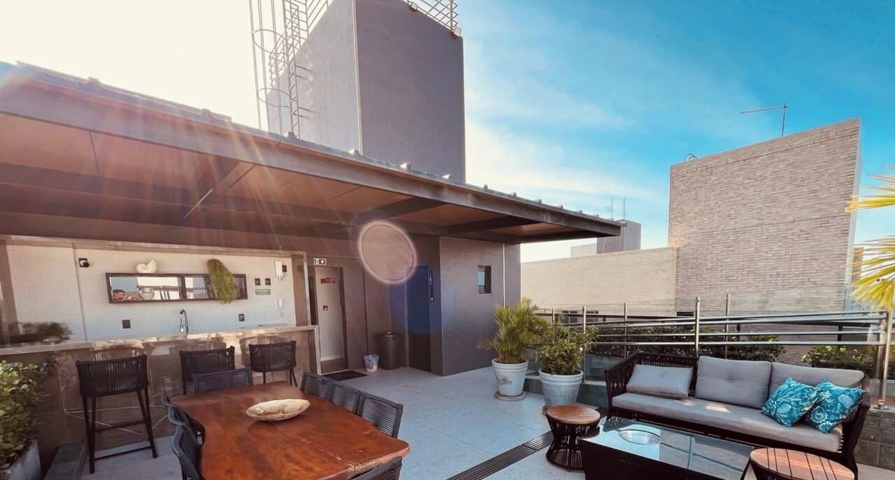 An outdoor patio with a dining table, chairs, a sofa, and a bar area with stools.