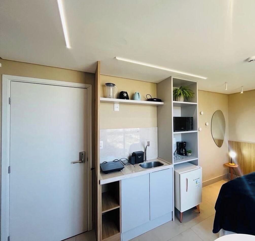 A compact kitchenette with a microwave, kettle, and coffee maker.