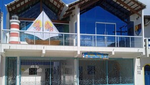 Ein zweistöckiges Gebäude mit Balkon und großem Fenster, mit einem Schild, auf dem "Hotel" steht.