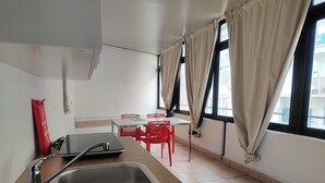 A kitchen with a sink, a table, and chairs. - CconfortHotels eXtramurale Apartment (Bari)