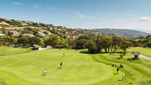 A golf course with players and a clubhouse. - T1 with exceptional sea view-HAMEAU CAP ESTEREL- VILLAGE VACANCES -AGAY (Saint-Raphaël)