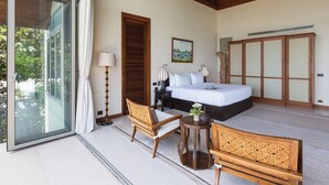Un dormitorio amplio con una cama grande, un armario y una zona de estar con una mesa.