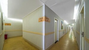 Pitkä, kapea käytävä, jonka molemmilla puolilla on ovia, ja jokaisen oven yläpuolella on kyltti, jossa on huoneen numero.