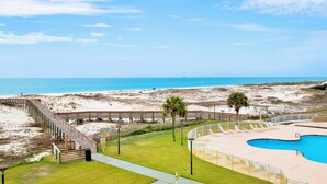 A beachside resort with a wooden boardwalk, a swimming pool, and a view of the ocean. - Beachfront  - Fantastic Beach Vacation for Family Fun (Gulf Shores)