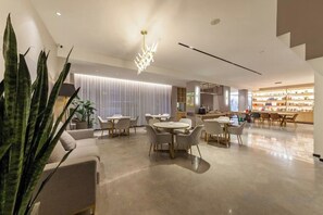 A modern interior with a dining area, kitchen, and bar/lounge area. - Allston Hotel (Xiamen)