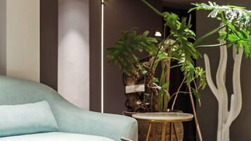A room with a light blue sofa, a round wooden table, and a potted plant.