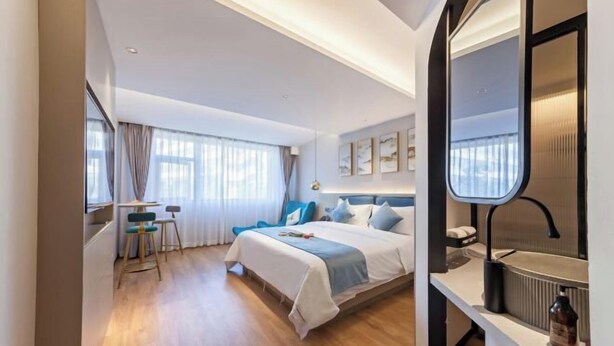 A modern hotel room with a bed, bedside table, and a large window. - Allston Hotel (Xiamen)
