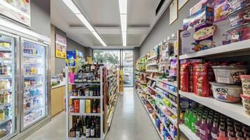 A grocery store aisle with refrigerated sections on the left and shelves stocked with various products on the right.