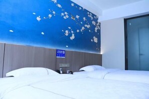 Une chambre d’hôtel avec un grand lit, un panneau numérique fixé au mur et une fenêtre.