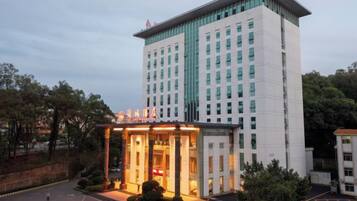 A multi-story hotel with a prominent entrance and a parking area.
