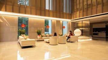 A spacious lobby with seating areas, a reception desk, and large windows.