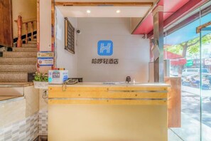 A hotel reception area with a reception desk, a staircase, and a view of the street outside. - Hello Lite Hotel (Nanjing Nanhu Lake) (Nanjing)