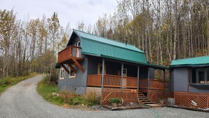 A cabin with a porch, a deck, and a gravel driveway. - Mountain Cabin in Palmer, Ak (Palmer)