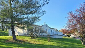 A white house with a front porch and a small lawn. - Peaceful Retreat on the Bourbon Trail (Lawrenceburg)
