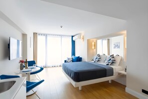 A modern hotel room with a large bed, a desk with a chair, a flat-screen TV, and a window with curtains. - Batumi Orbi City Sea View (Batumi)
