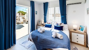 A bedroom with a bed, a nightstand, a window, and curtains. - R1385 | Villa Emma, La Exótica (Nerja)