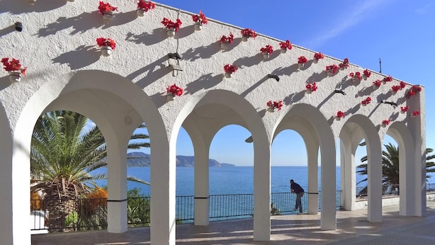 A covered walkway with white arches and red flowers, leading to a seaside view. - R1385 | Villa Emma, La Exótica (Nerja)