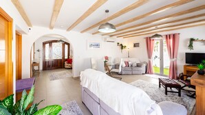 A spacious living area with a sofa, a bench, a TV, and a dining table. - R1385 | Villa Emma, La Exótica (Nerja)