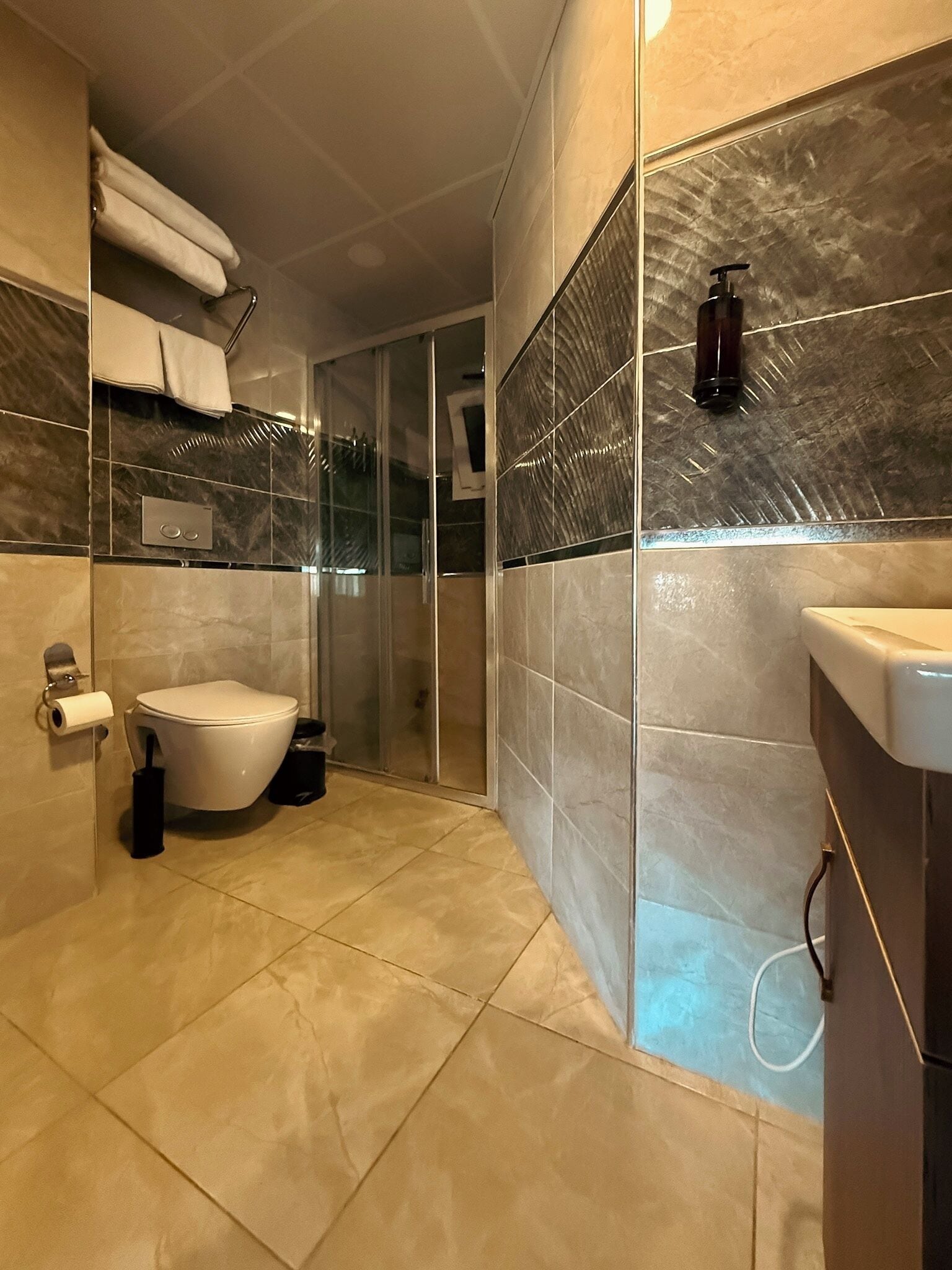 Un baño moderno con inodoro, ducha y lavamanos.