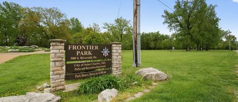 A sign for Frontier Park, including its address and park hours.
