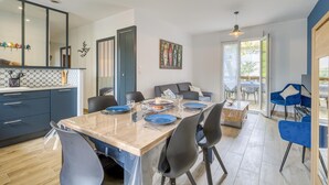 Een moderne keuken met een eethoek, met een grote tafel met stoelen, een keukenblad en uitzicht op de omgeving.