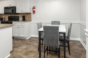 A kitchen with white cabinets, a microwave, a coffee maker, and a fire extinguisher. - Budget 1BR Near Ft. Moore & Airport w. HDTV & WiFi (Columbus)