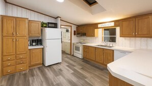 Une cuisine moderne avec des meubles en bois, un réfrigérateur, un four à micro-ondes, une cuisinière et un évier.