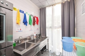 A hotel bathroom with two sinks, a mirror, and a window with curtains. - Xingji Hotel (Shanghai)