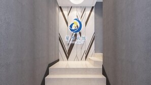 Een modern hotelinterieur met een trap naar een receptie.