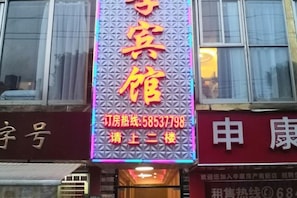 A hotel sign with a contact number and a note to call the second floor. - Xingji Hotel (Shanghai)
