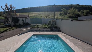 A rectangular swimming pool with clear blue water, surrounded by a tiled deck and a low wall. - Charming house - Swimming pool - 11 beds - 15 travellers - Pets OK - Cluny (Azé)