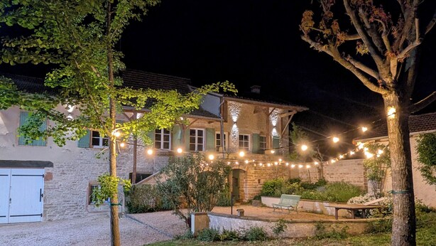 A stone building with a gravel driveway, a grassy lawn, and string lights. - Charming house - Swimming pool - 11 beds - 15 travellers - Pets OK - Cluny (Azé)