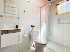 Un bagno moderno con WC, lavabo e doccia.