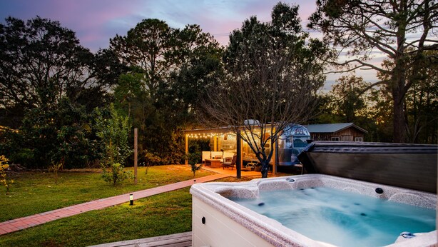 A hot tub on a wooden deck with a grassy yard and trees in the background. - Creekside Retreat w/ Hot Tub + Game Room, 6 minutes to Downtown, 15 to Folly! (Charleston)