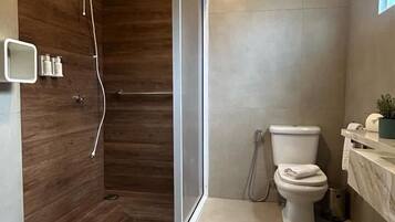 Een moderne badkamer met een douche, toilet en wastafel.