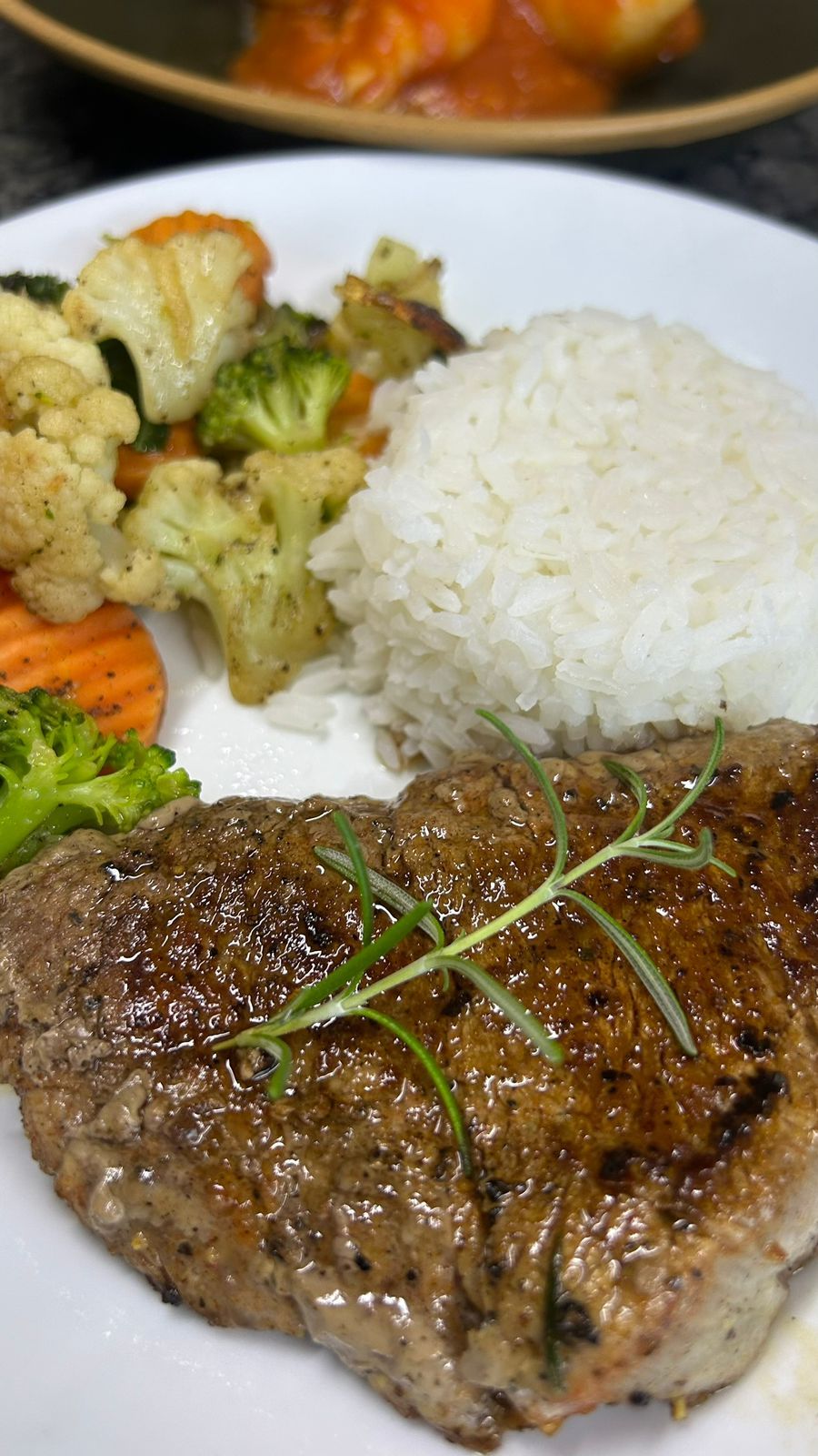 Une assiette comprenant un steak grillé, des légumes cuits à la vapeur et du riz blanc.