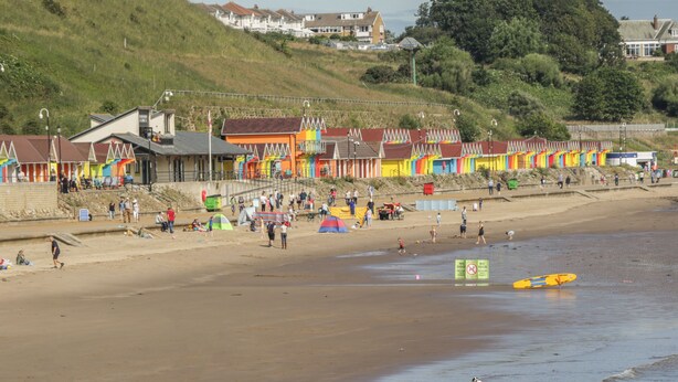 A beach with colorful beach huts and a sandy shore. - The Newborough Apartment 5 (Scarborough)
