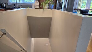 A modern kitchen with wooden cabinets, a stainless steel refrigerator, and a potted plant on the counter.
