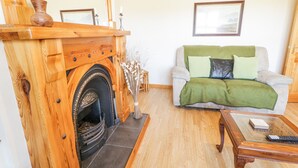 A living room with a fireplace, a sofa, and a coffee table. - Mountain View (Ballymoney)