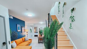 Una sala moderna con un sofá, un comedor y una escalera.