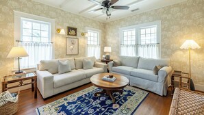 A living room with two sofas, a coffee table, and a ceiling fan. - The Hansell House, your Downtown Thomasville Destination! Family + Pet Friendly! (Thomasville)