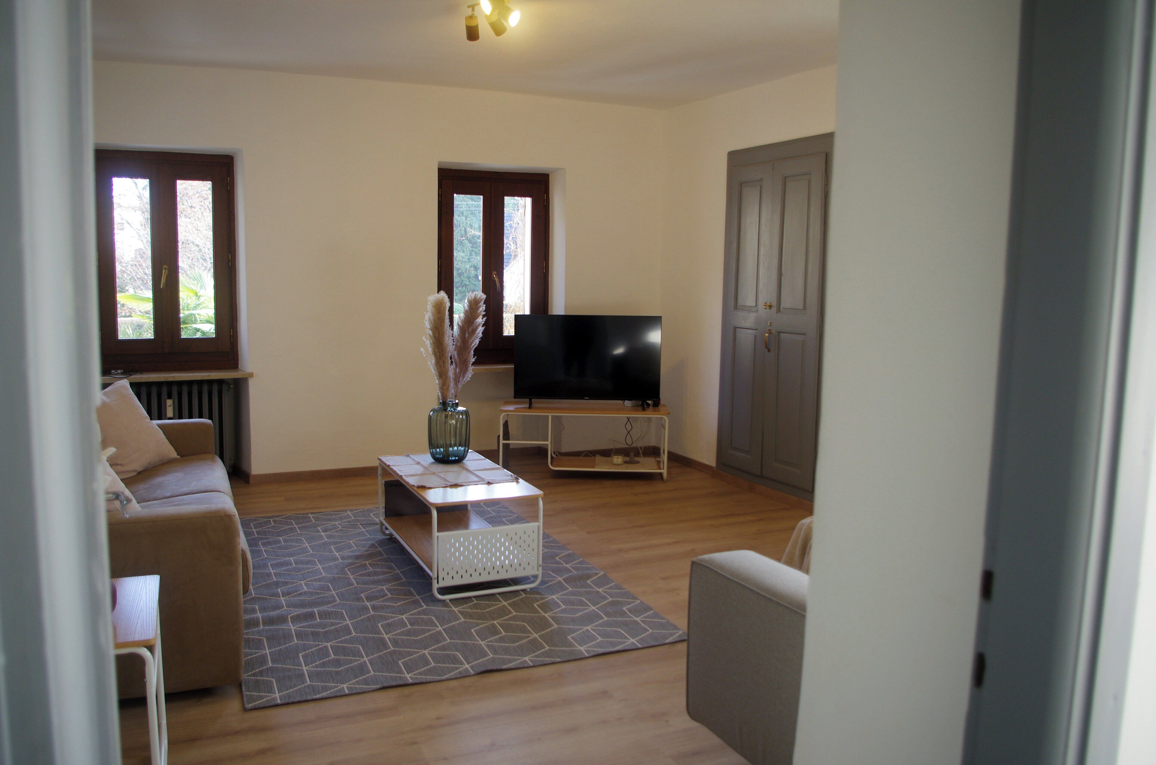 A living room with a sofa, a coffee table, a TV, and a door.