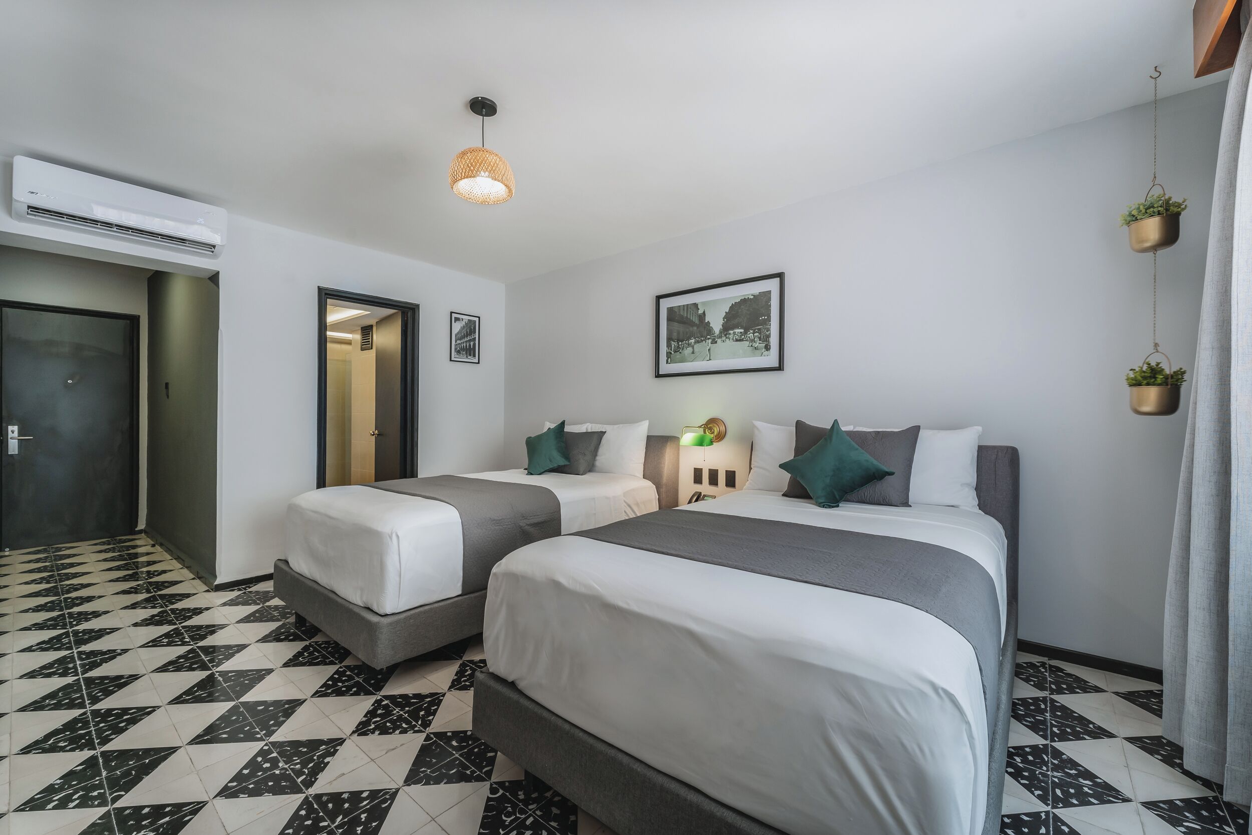 Ein Hotelzimmer mit zwei Betten, einer Rezeption und einem gerahmten Bild an der Wand.