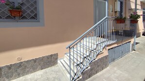 A staircase with a metal railing leading to a covered porch area. - Vacation Home Southern Geko (Torre del Greco)